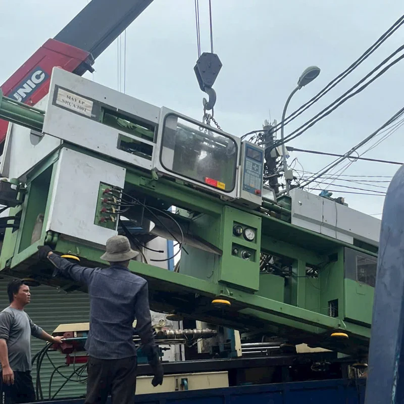 Cẩu máy ép nhựa lên xe tải trong một đợt thanh lý máy móc