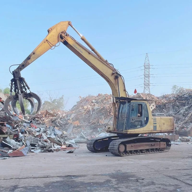 Máy xúc gắp phế liệu tại bãi tháo dỡ của Phế Liệu Thành Long