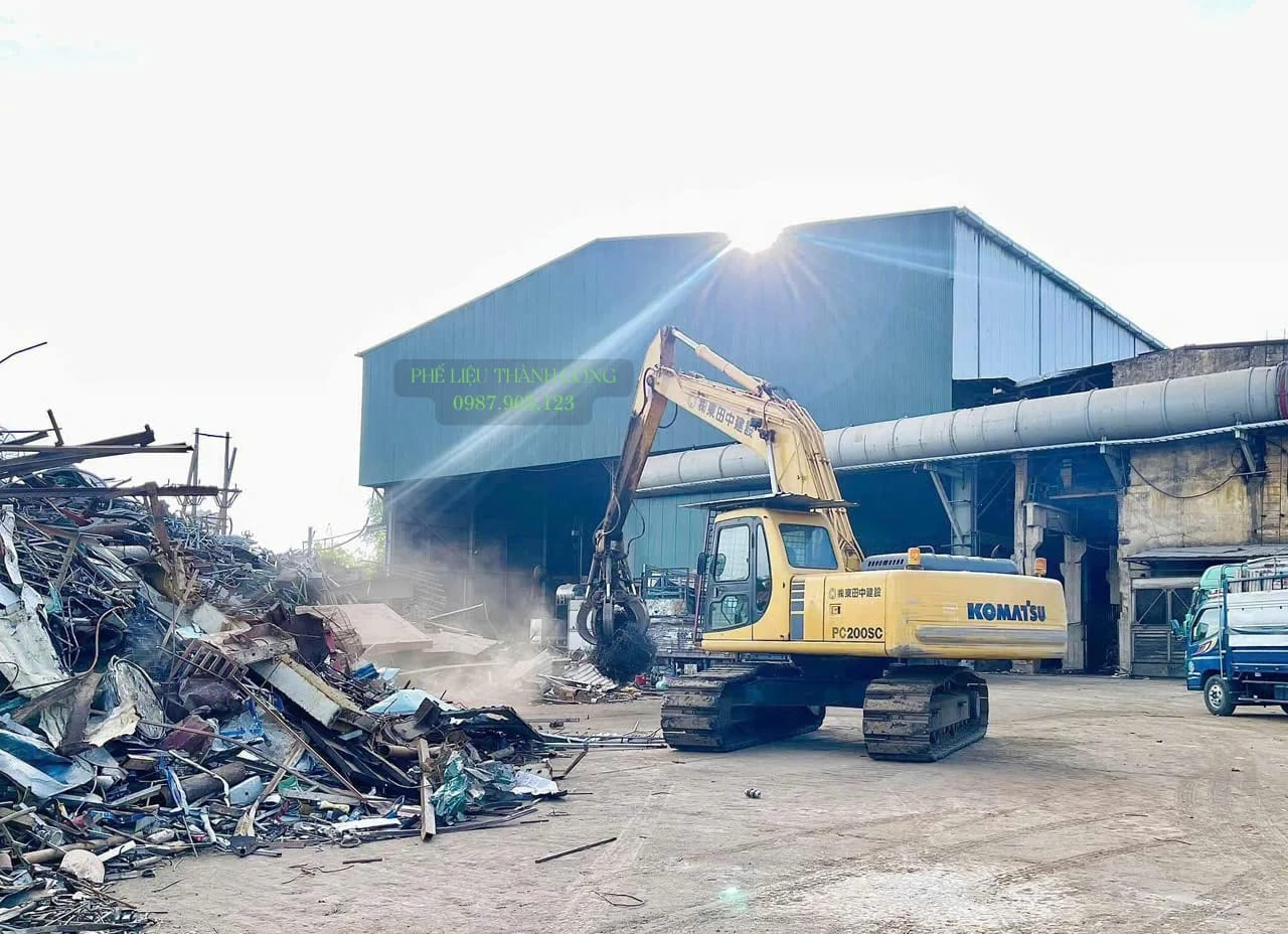 Xe cuốc gắn kìm bốc phế liệu tại bãi Bình Trị Đông