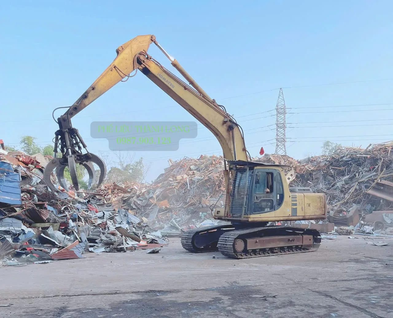 Xe cuốc gắn kìm gắp phế liệu tại bãi ở Đồng Tháp