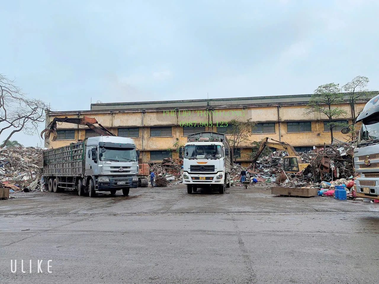 Xe tải và xe cuốc bốc phế liệu tại bãi Bình Trị Đông