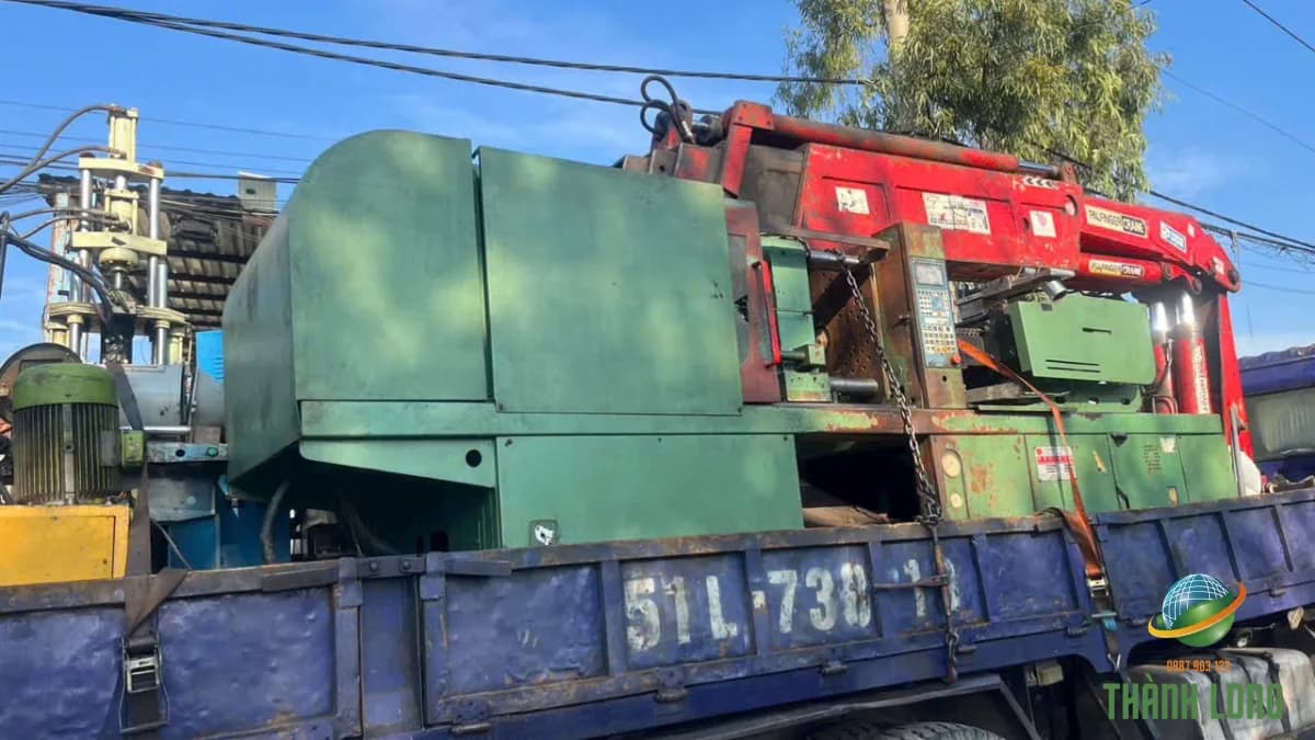 Máy móc công nghiệp cũ được cẩu và vận chuyển bằng xe tải